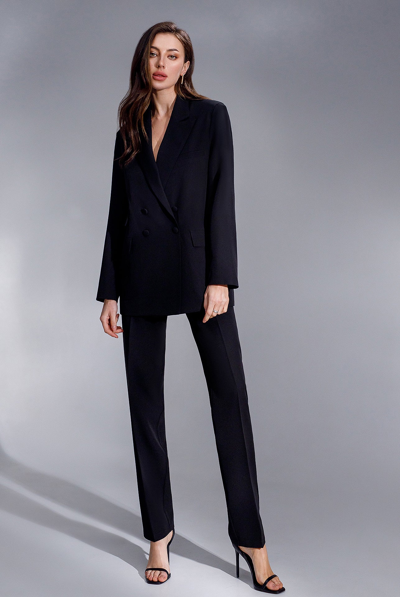 ELAGIA black double-breasted suit close-up of gold button details and lapel construction on blazer