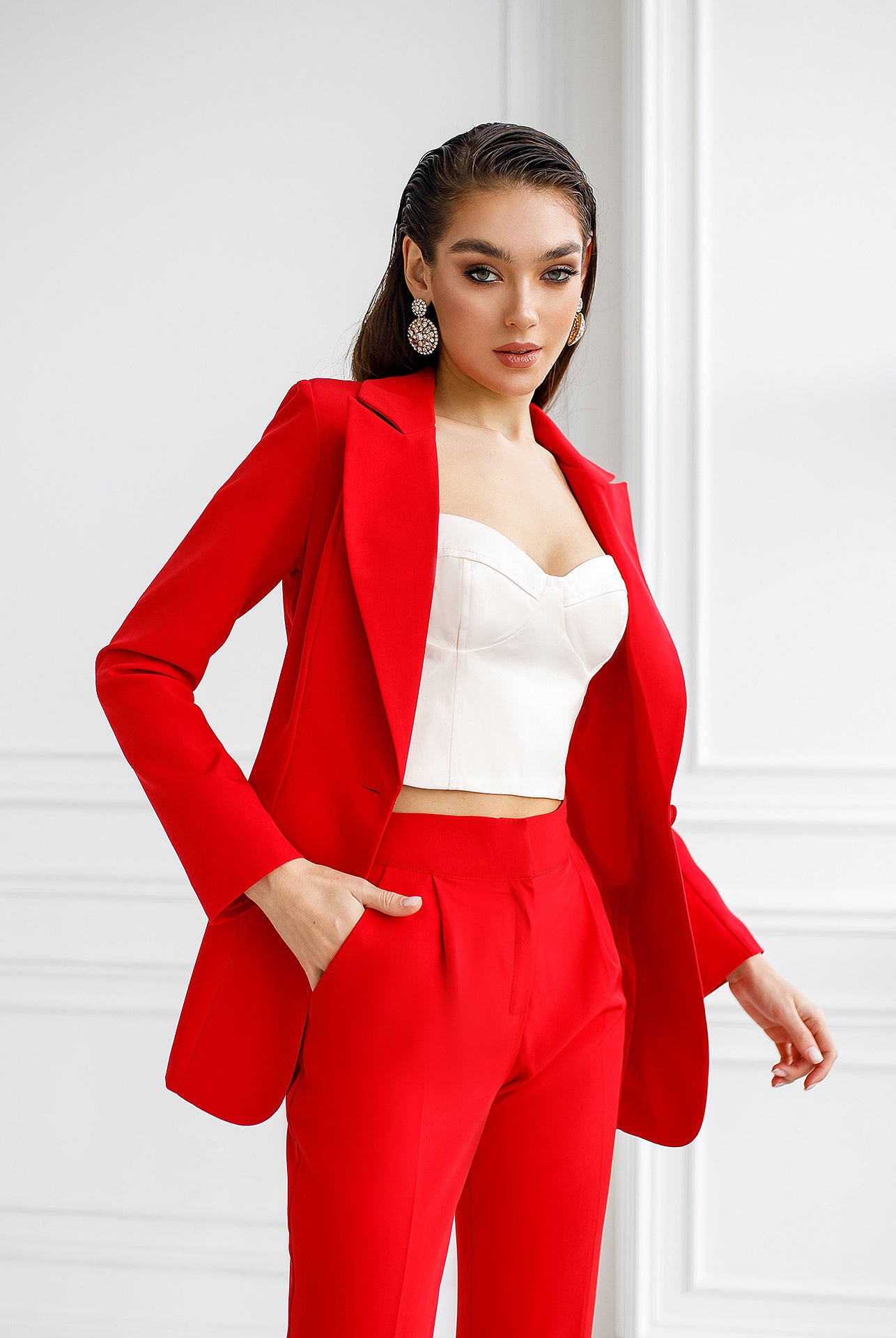 ELAGIA red suit side angle displaying single-breasted blazer lapels and straight-leg trouser cut
