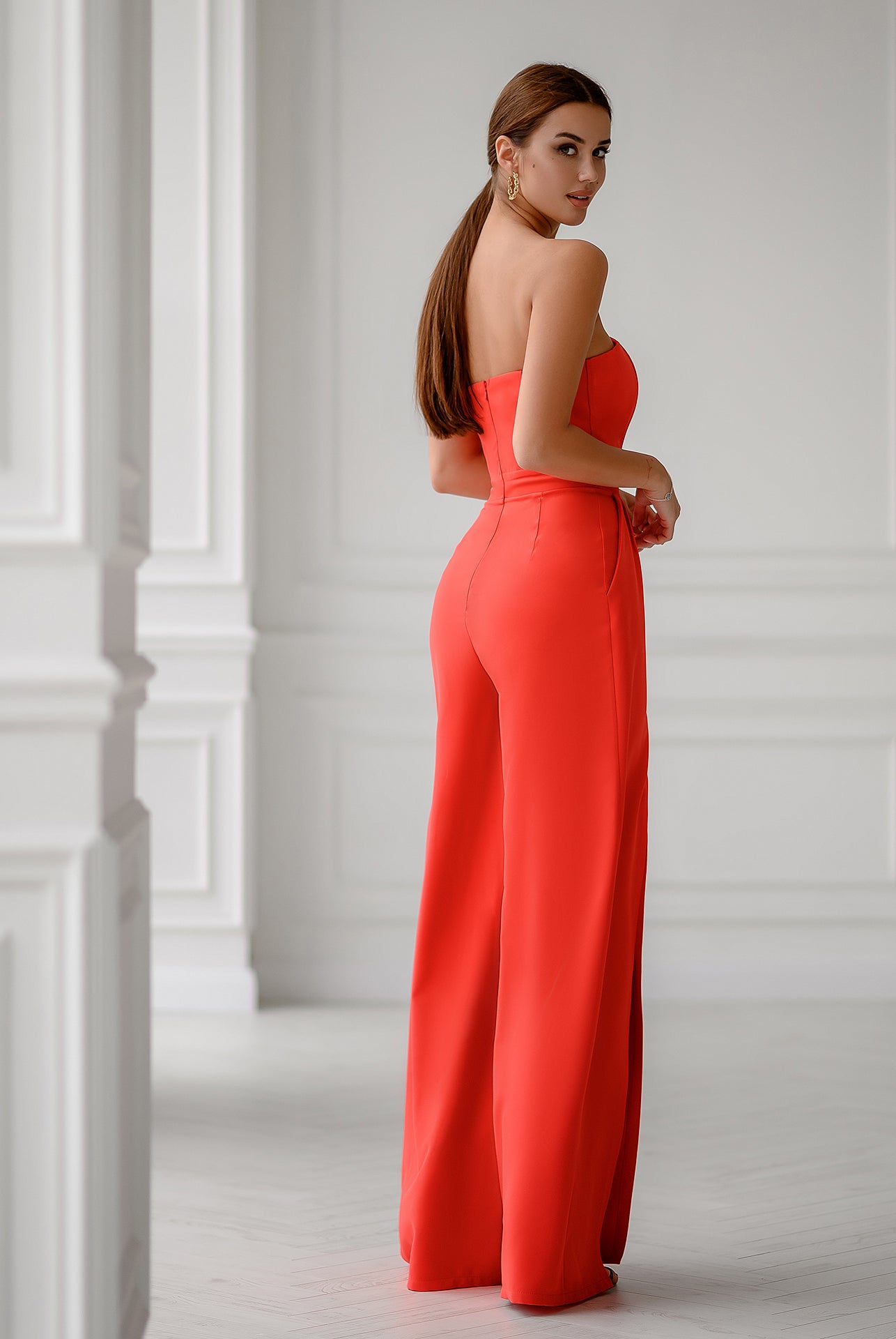 ELAGIA coral jumpsuit side profile detail highlighting strapless v neck structure and tailored fit