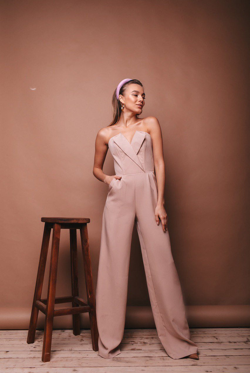 ELAGIA beige V-neck sleeveless jumpsuit lifestyle shot - blue jumpsuit modeled in natural setting or pose