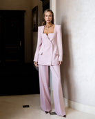Pink square-neck double-breasted suit in crepe fabric, front view showing structured blazer and tailored trousers