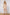 ELAGIA gold one-shoulder satin mini dress back view showing draped silhouette and zipper closure