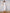 ELAGIA white one-shoulder belted midi dress, three-quarter view displaying the sophisticated cut and fit