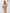 Lifestyle shot of ELAGIA beige off-the-shoulder maxi dress styled for occasion wear
